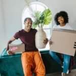Couple holding moving boxes